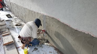 A scratch coat is put on the brick with acrylic bonder in the mortar