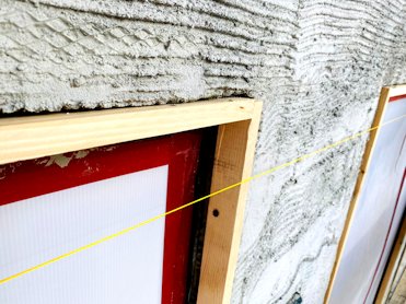 Walls are straightened by setting wood strips with a string line.