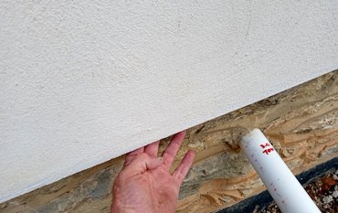 Stucco projects past the foundation for a drip edge.