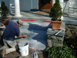 Concrete steps repaired and coated with a blue stucco finish.