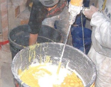 Mixing yellow plaster for the hallway