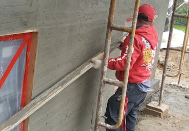 Wall is filled and rodded off between the strips.