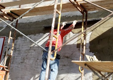 Wall is straightened by setting a horizontal screed.