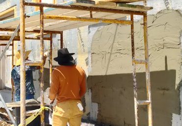 Scratching mortar on metal lath.