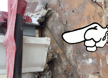 Water runs off the roof between the gutter and the wall