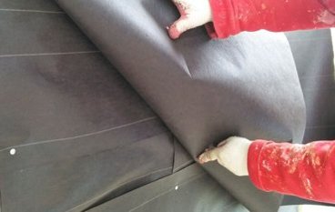Finger shows the lap in the first layer is overlapped by the second.