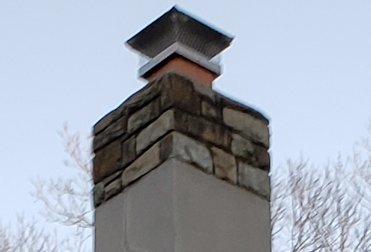 The top of the chimney has a soft very porous mortar and is almost flat.