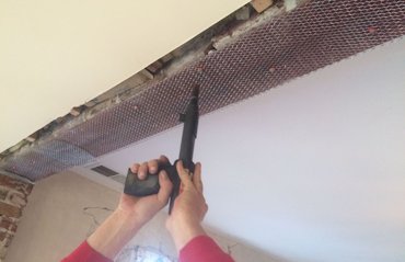 Metal lath is shot to the steel beam using a ramset gun in Takoma Park