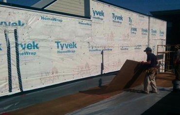 The roof is covered with plastic and thick
                masonite before setting up scaffold