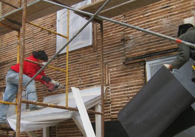 Old stucco stripped
                off to the old wood lath