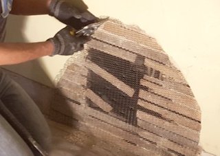 Metal lath is screwed on over the old wood lath