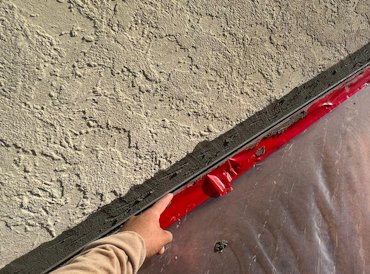 Stucco projects past the foundation for a drip edge.
