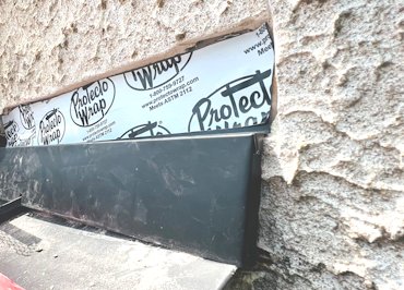 Protecto wrap is cut off tight to the underside of the stucco
