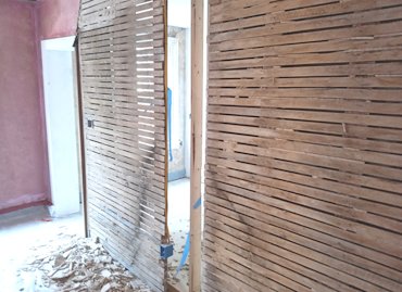 Loose plaster was stripped off the wood lath