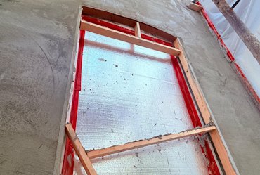wood strips to form window returns are wedged with
            lumber.
