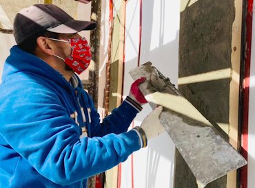 Walls are filled and rodded off between the wood strips.