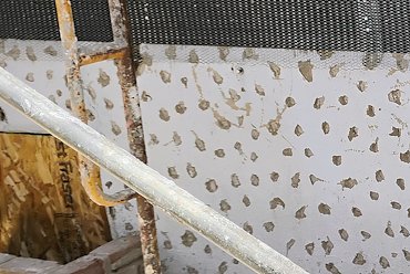Painted foundation walls are chipped and prepared.
