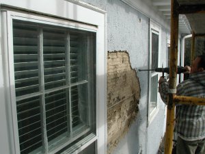 Old stucco is torn off with electric chipping
              hammers in Washington, DC